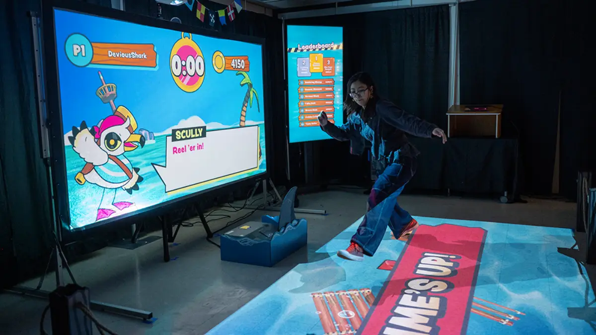 Women playing a game on a projected screen and floor projection
