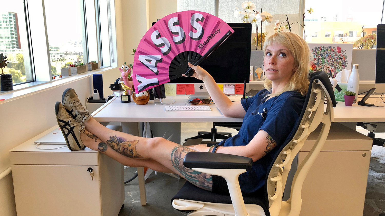 Linzi Berry waving a big fan in the office