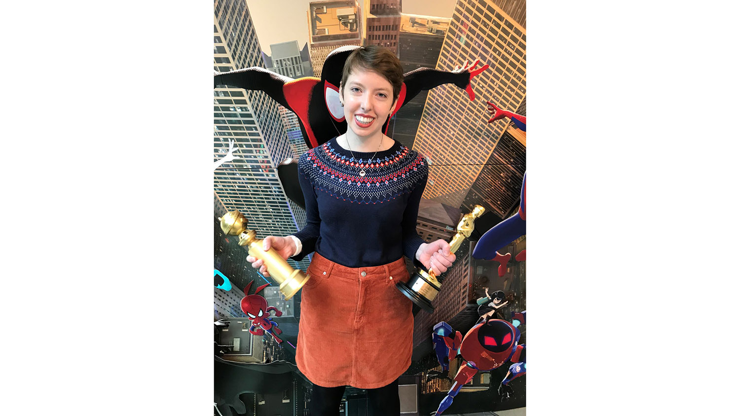 An alumna holding awards won by a film she worked on