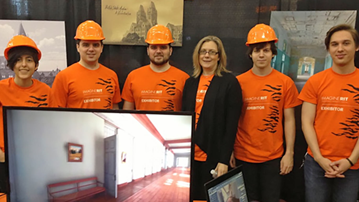 Exhibitors of the project stand in front of a display showing a 3D rendering