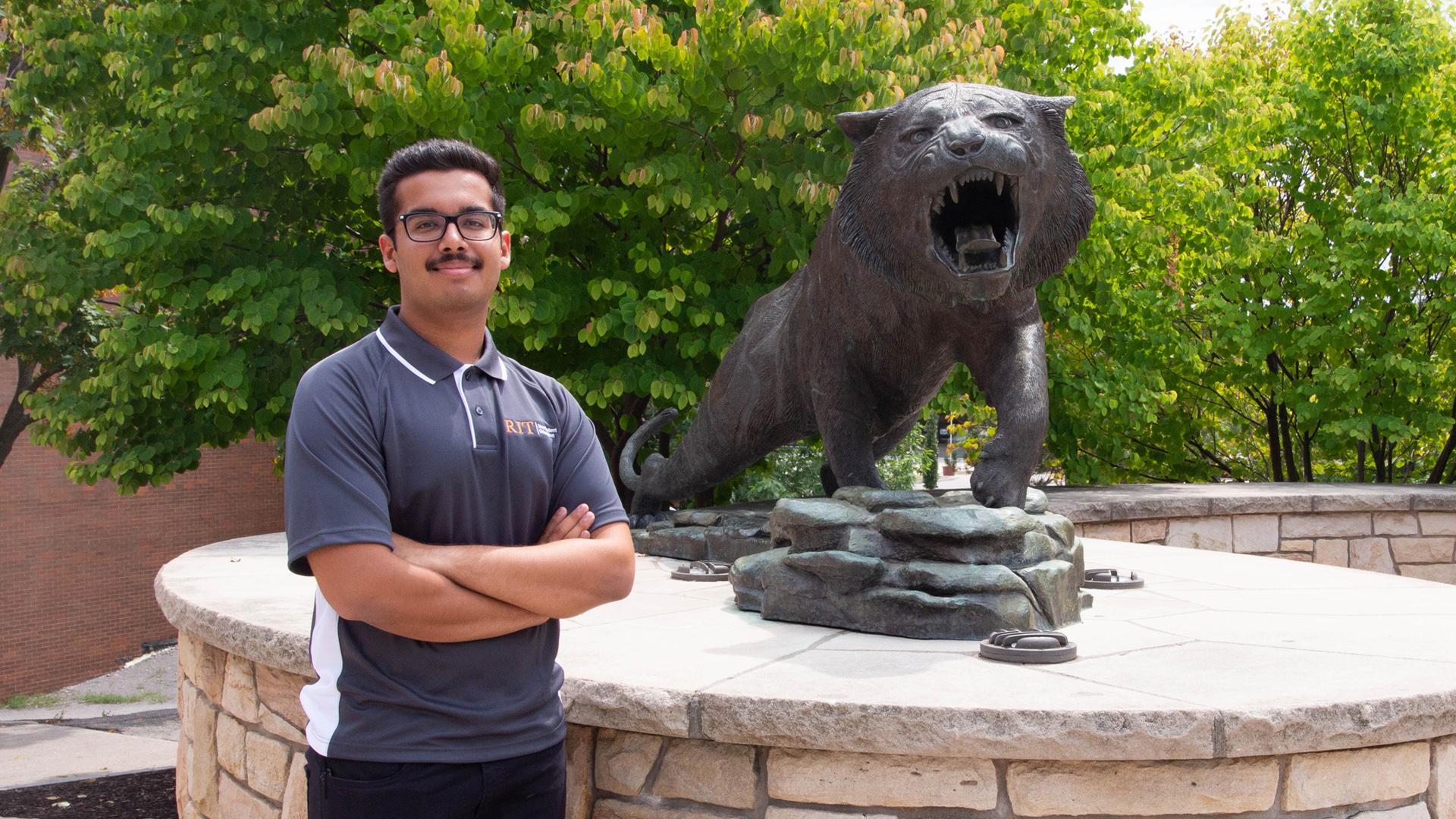 Student Ayush Goel poses by the RIT Tiger statue.