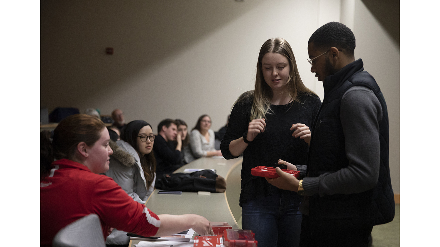 Two students show off their product packaging designs to a Milwaukee Tool representative. 