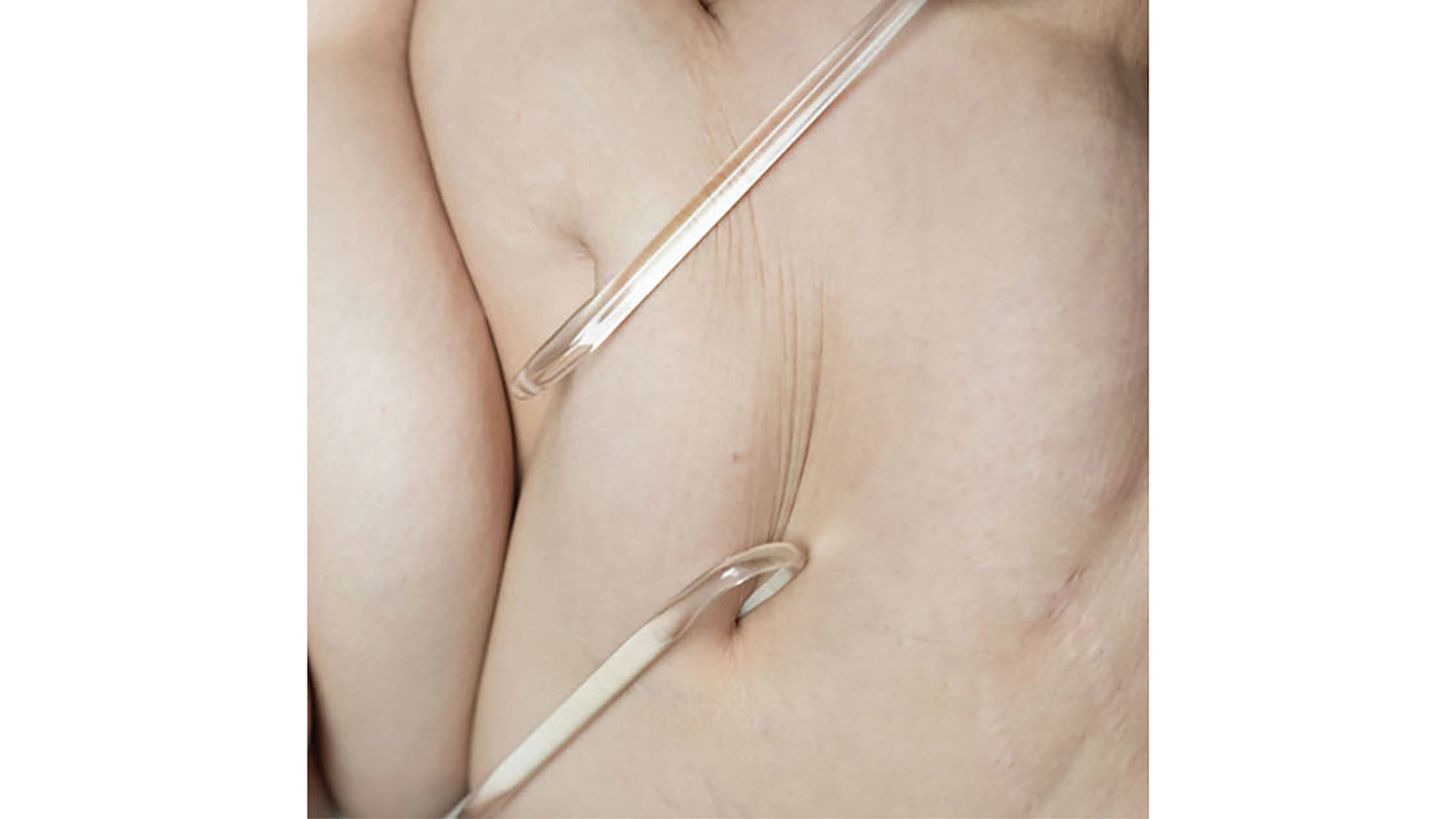 Glass hooks pull on flesh to demonstrate the material's fragility.