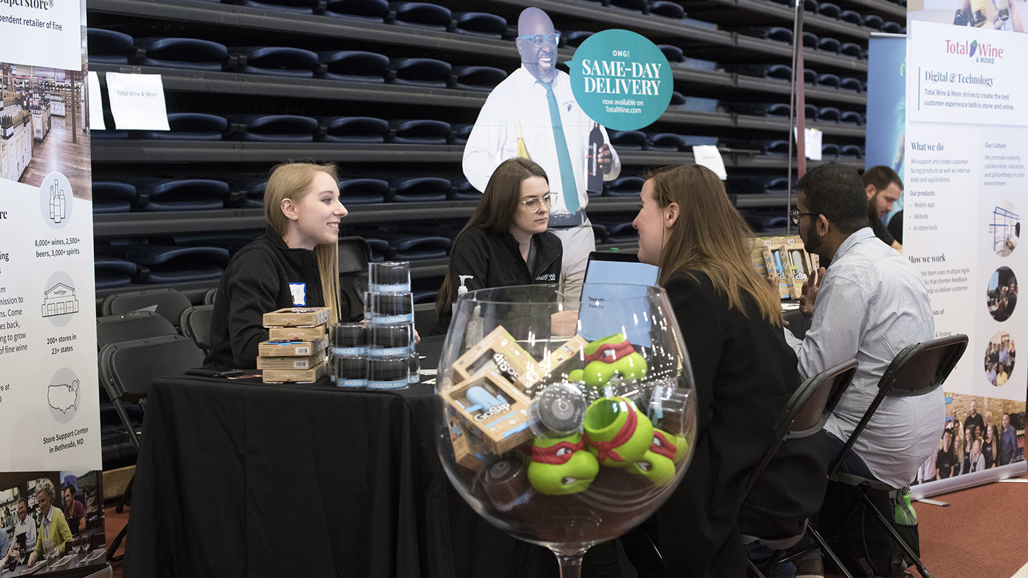 Two alumni working at Total Wine & More staff a table at RIT's 2020 Creative Industry Day. Becky does UX design at Total Wine.