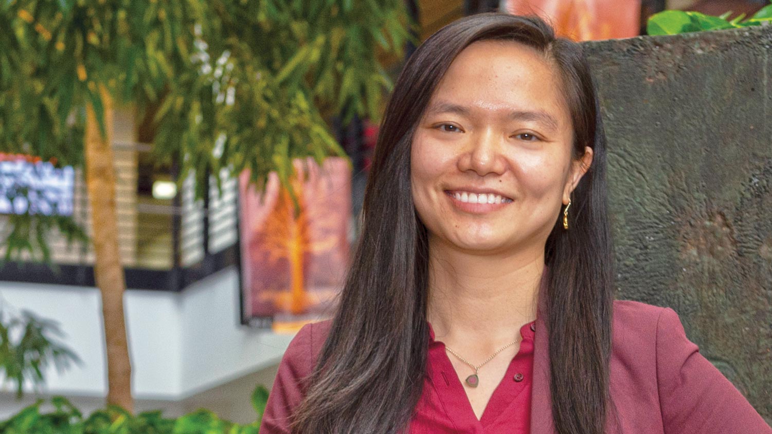 Linwei Wang stands in the lobby of the Golisano College of Computing and Information Sciences.