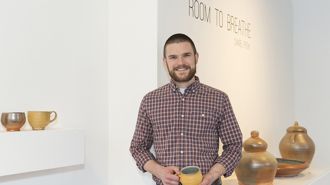 Dan Pfohl poses for a portrait in a gallery.