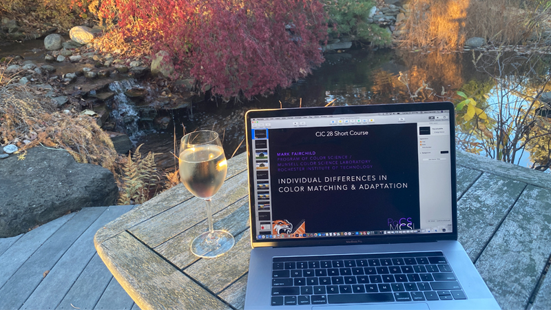 wine glass next to a laptop outside