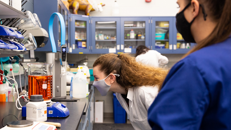 bioprep student reading measurements on a filled beaker