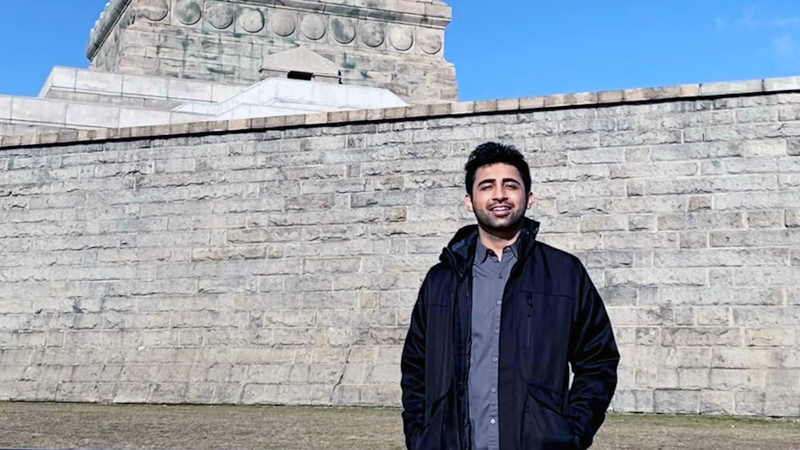 Aasim Jan standing in front of the Statue of Liberty