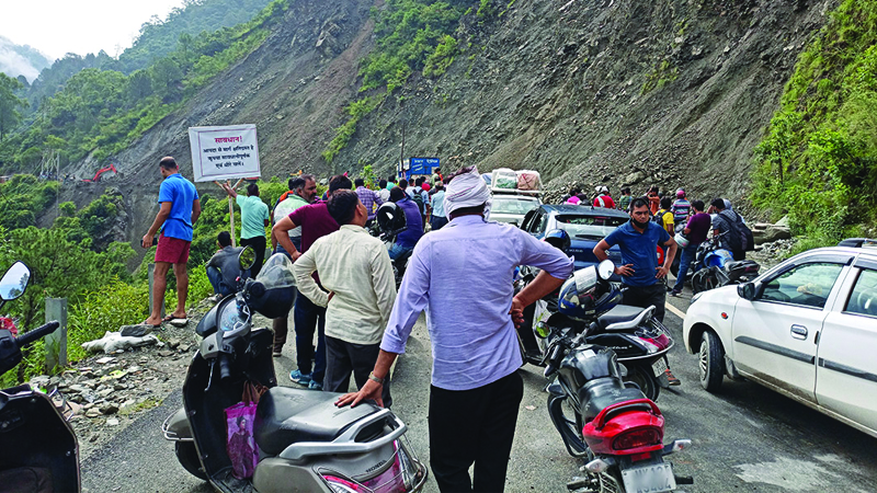 group of people looking at a landslide in the road