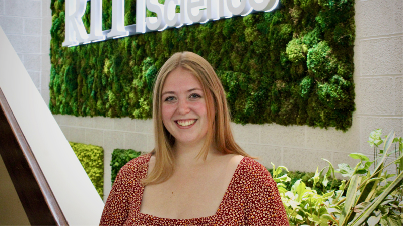 Kelsey Lawton standing in front of College of Science sign