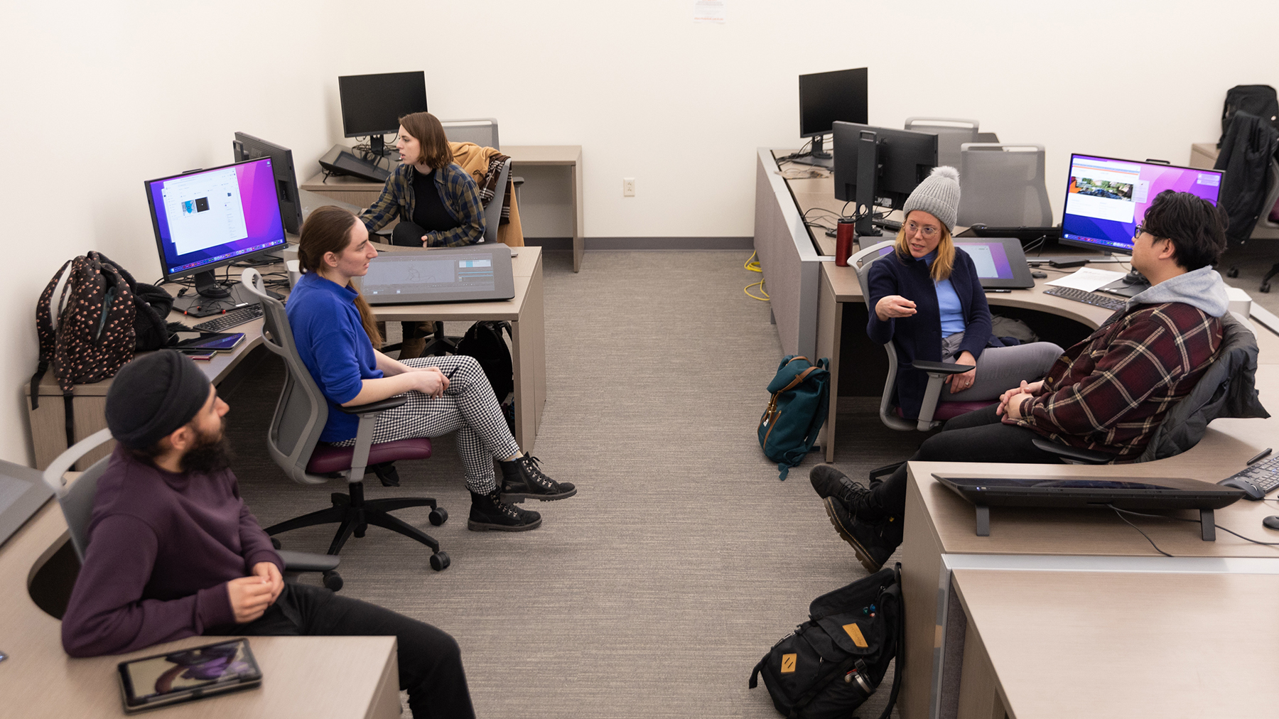 Students work and collaborate in a large computer lab.