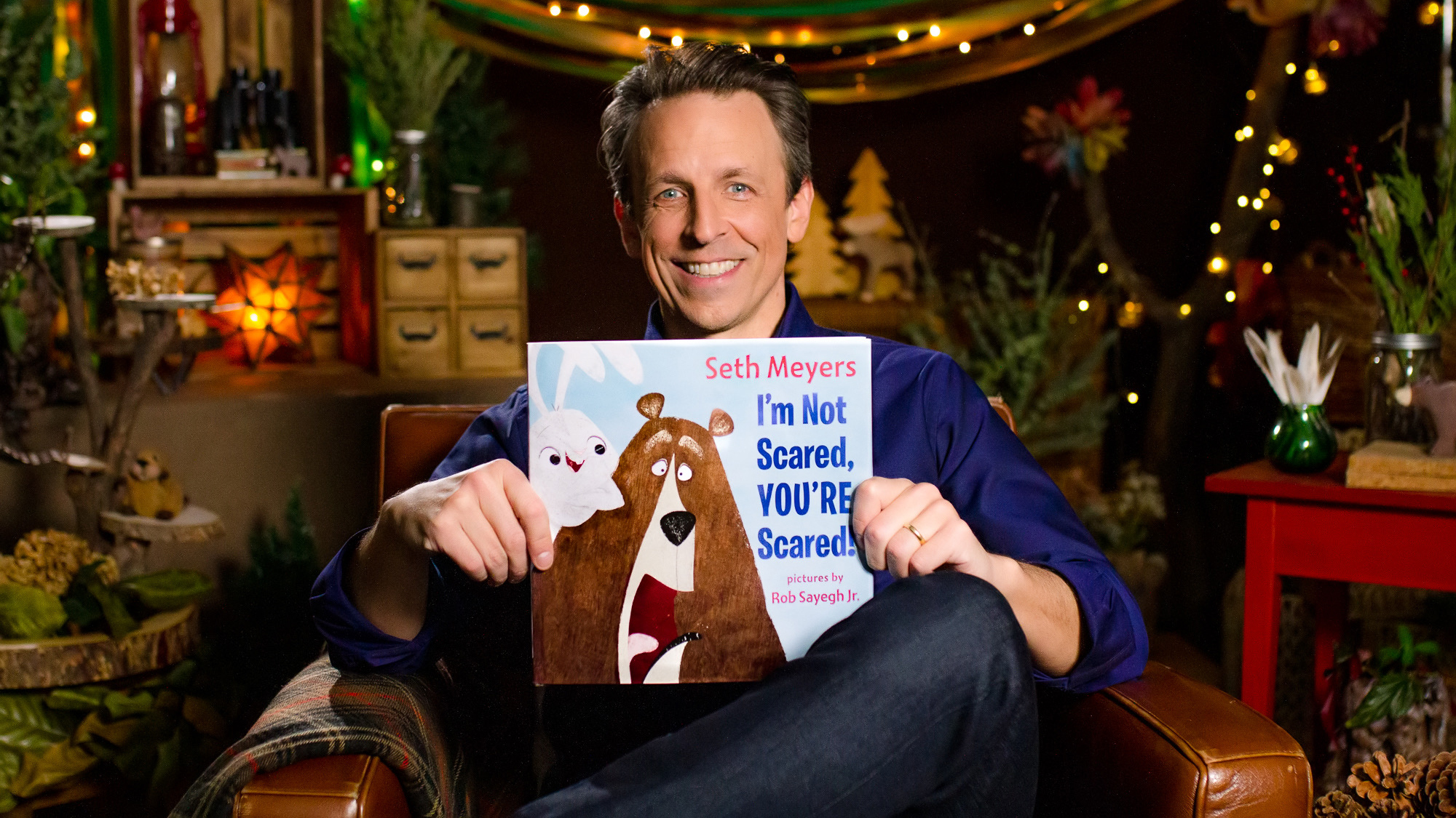 Seth Meyers holds up his children's book he wrote.