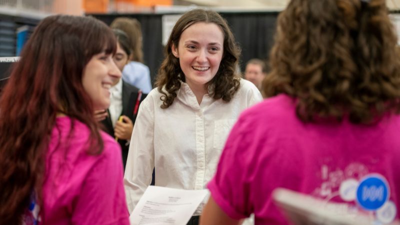 a student at the RIT career fair talking to two recruiters