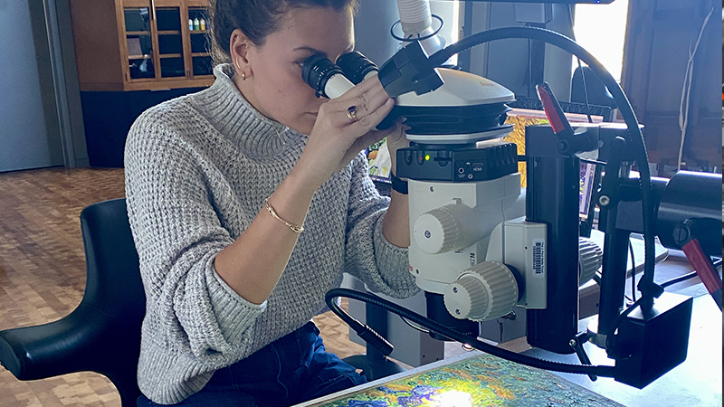 Oliva Kuzio looking into a microscope