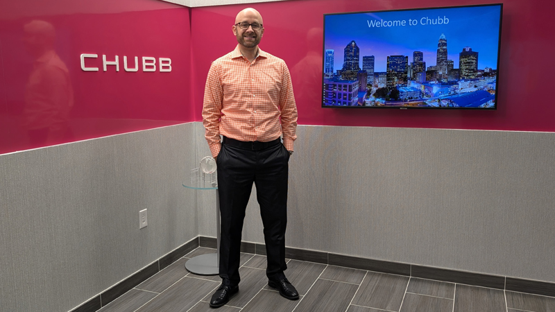 Andy Totman standing in front of a CHUBB sign