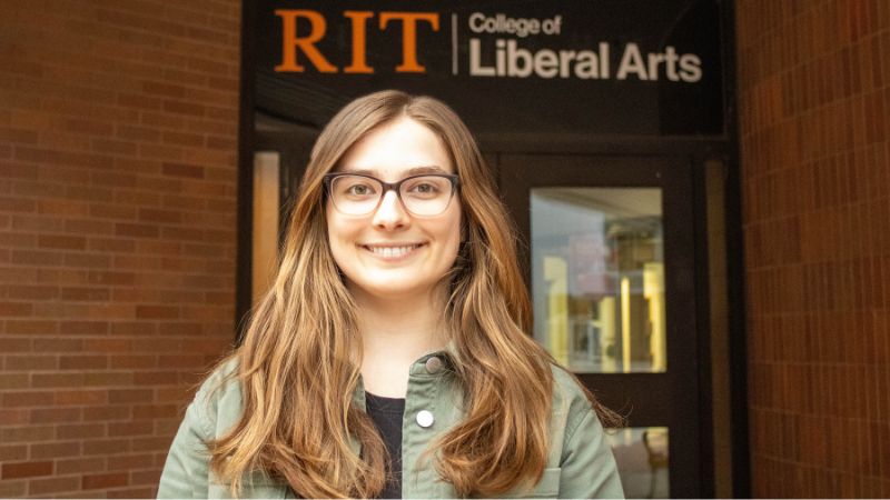 adrienne standing outside of the college of liberal arts 