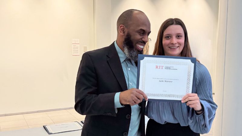 Sam at an award ceremony with Dr. Irshad Altheimer