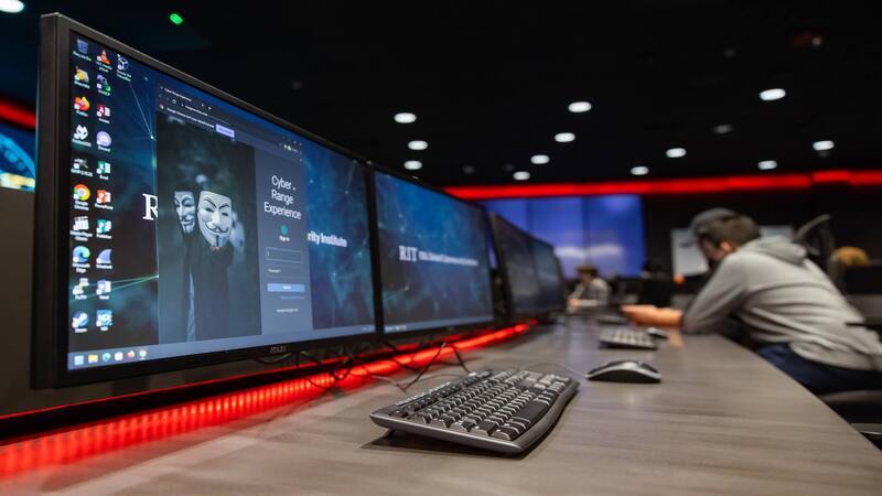 Multiple computer screens on with keyboards
