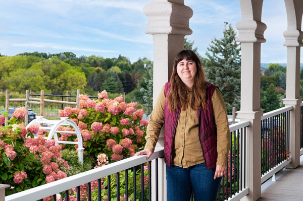 Tara Sarkin standing on balcony in front of flowers at Casa Larga Winery