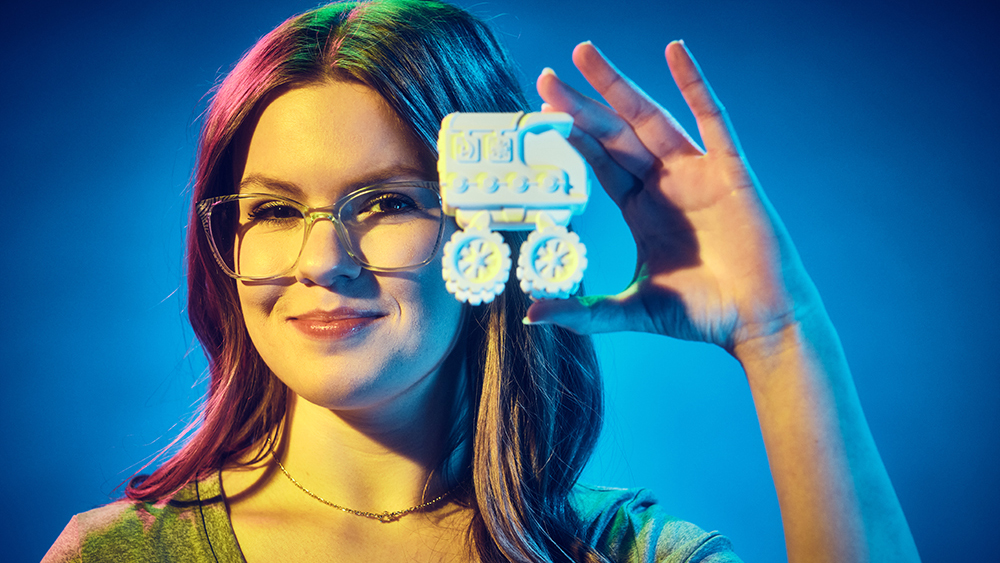 Ava Guarino holds up a 3D-printed toy truck.