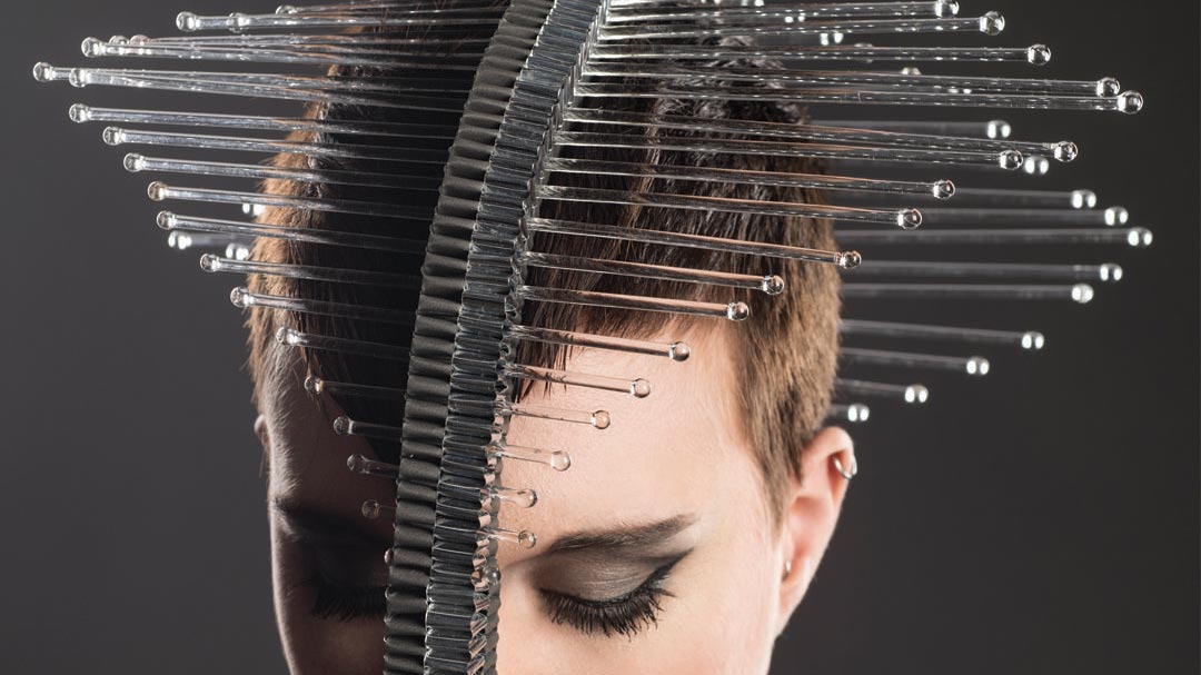 headwear with a strip of folded metal running along the top of the model's head to the chin, with glasses tubes sticking out horizontally from the forehead to the back of the head.