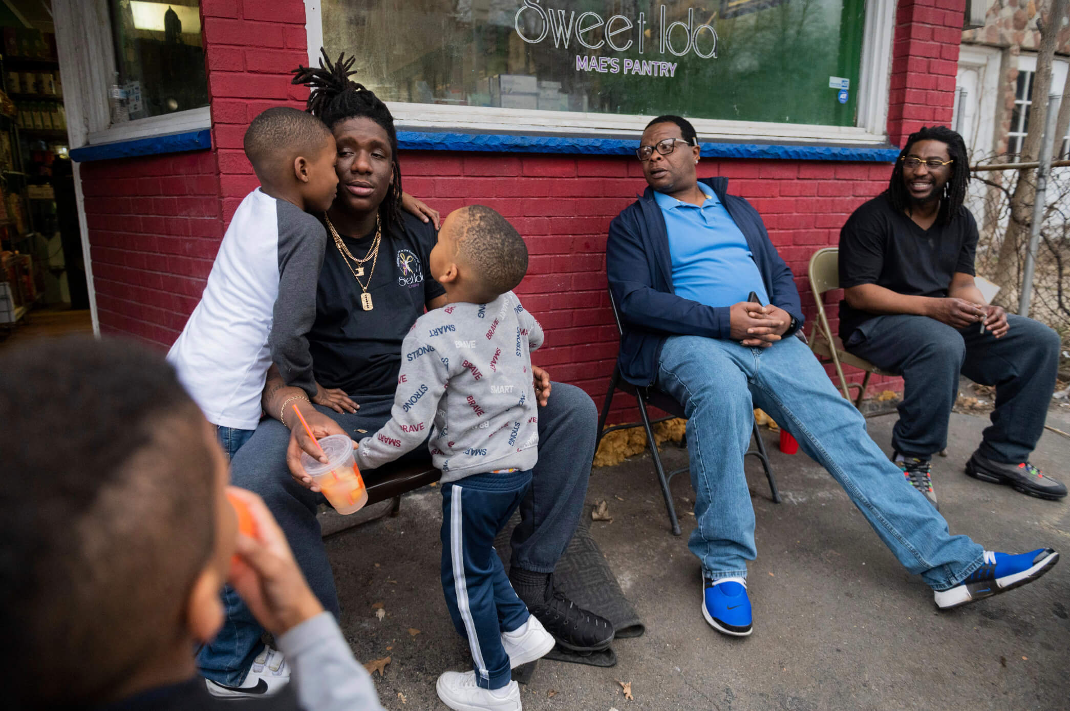 people sitting outside a city storefront.