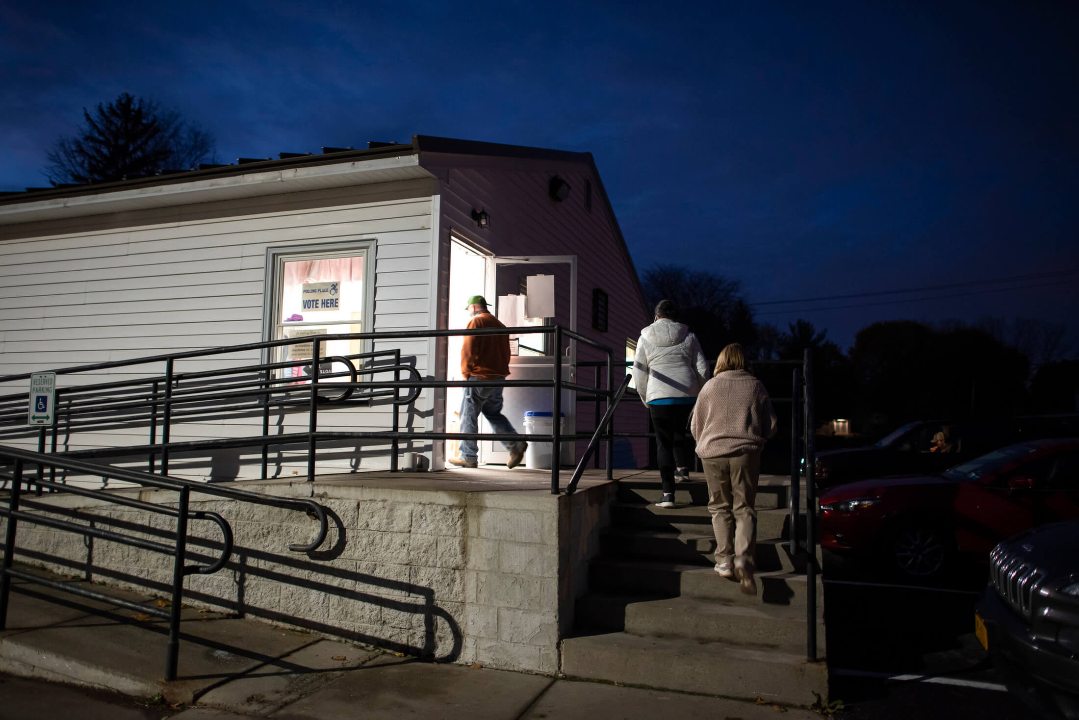 people walking into a polling location while it's dark out.