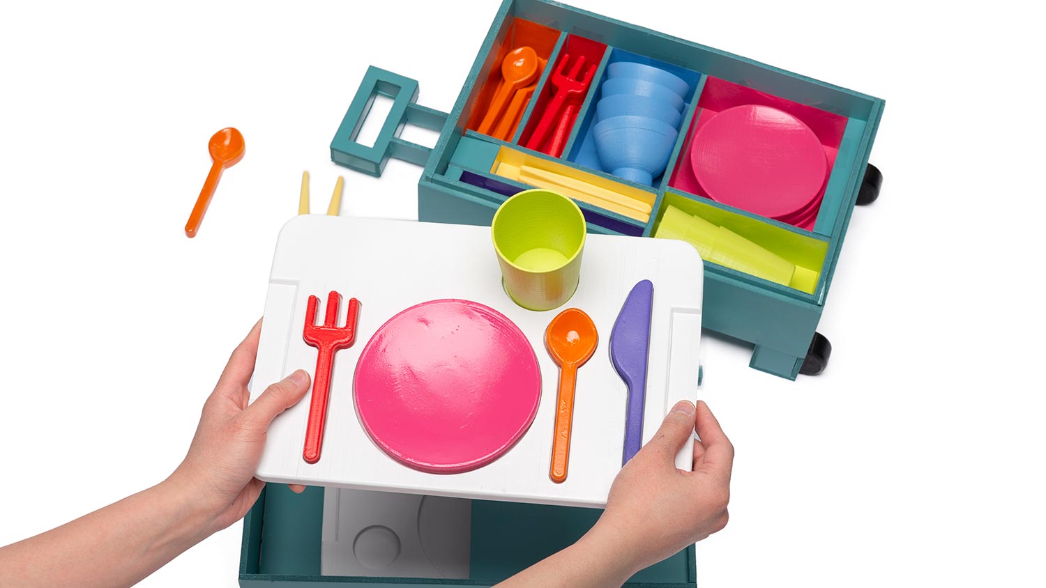 a place setting toy with colorful plates, silverware, and cups in a carrying case.