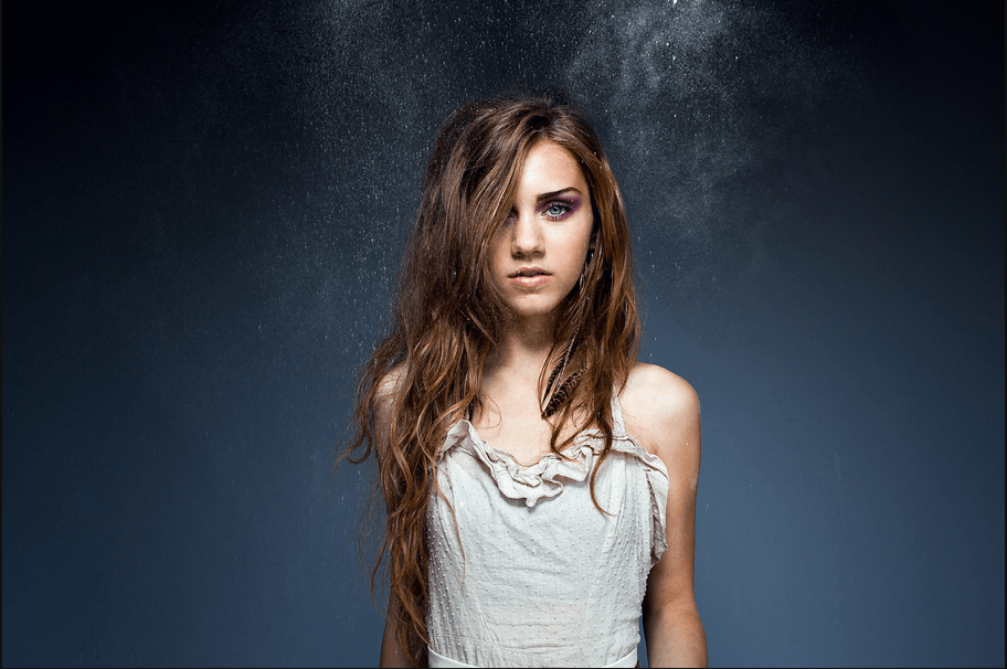 female model with a white peasant dress and long brunette hair.