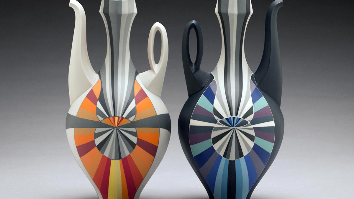 two a vase-shaped pitchers with a handle and a flaring spout, one with a geometric design in black, white, red, and orange, and the other with black, white, purple, and blue.