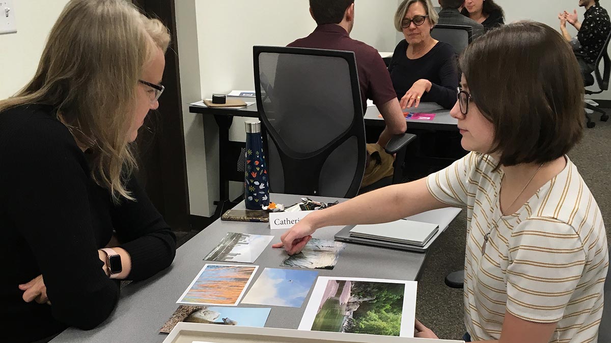 student and reviewer look at photography samples.