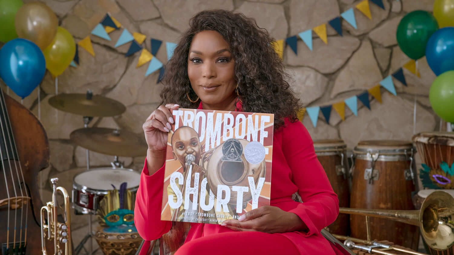 Angela Bassett holds an album for Trombone Shorty.