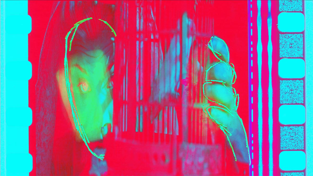 a person's face and hand, with a red screen overlayed on top and green animation over the face.